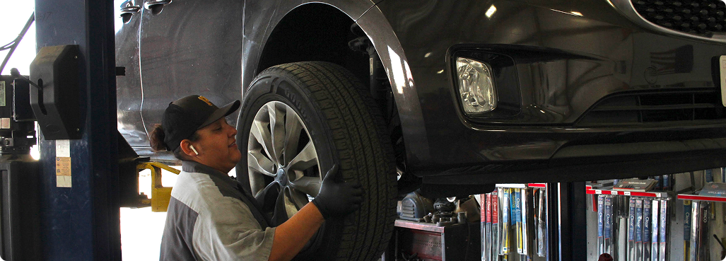Cars being serviced on lifts inside an auto repair shop.