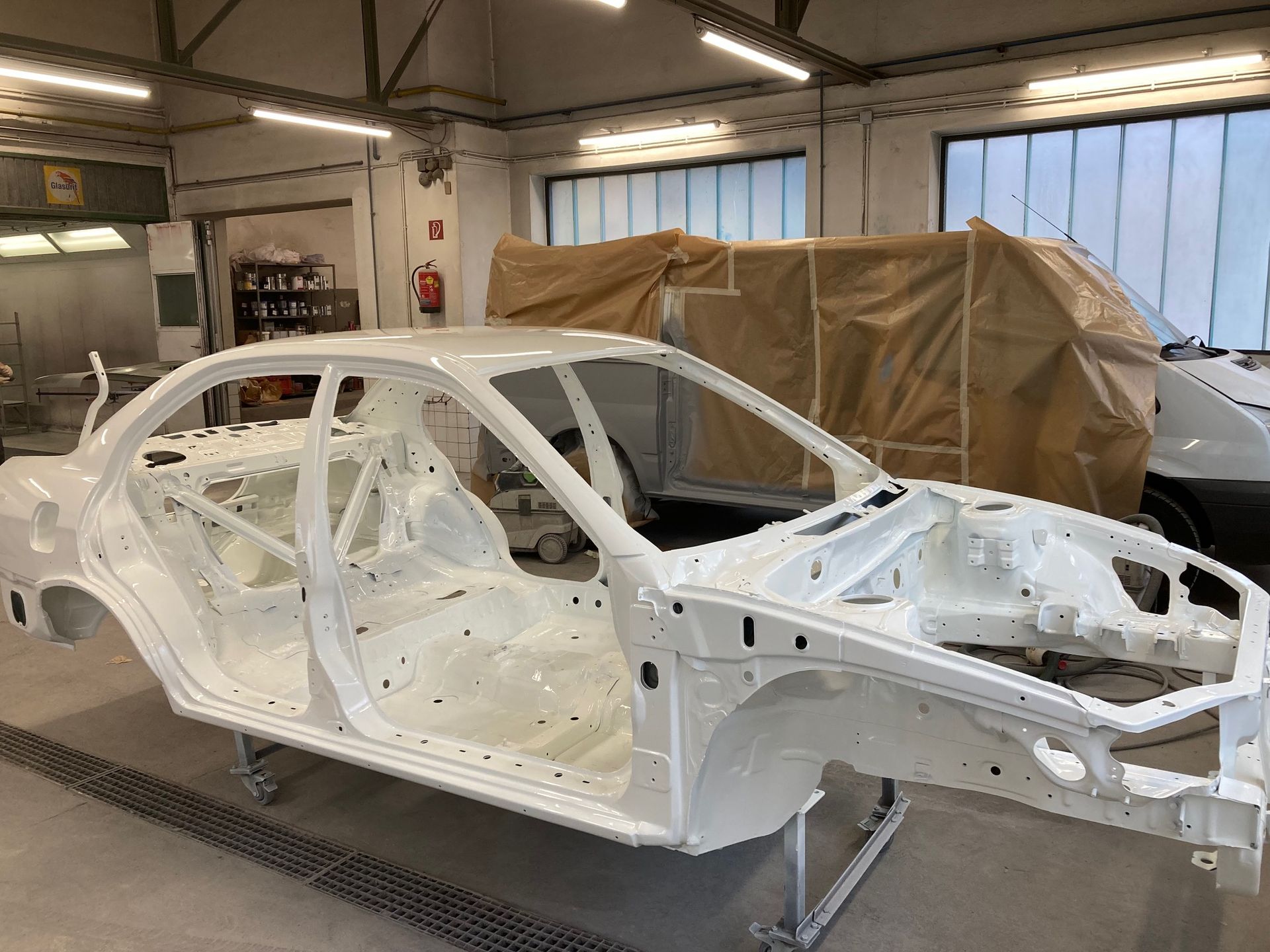 Ein weißes Auto wird in einer Garage lackiert.