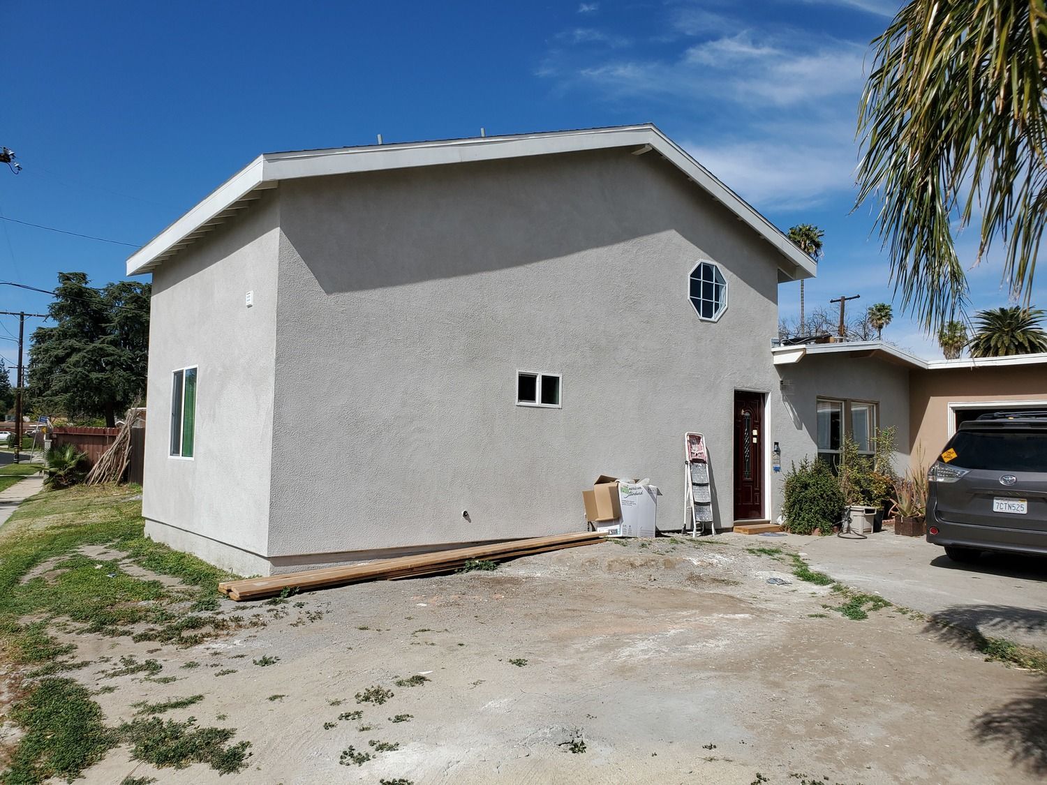 A small house with a car parked in front of it