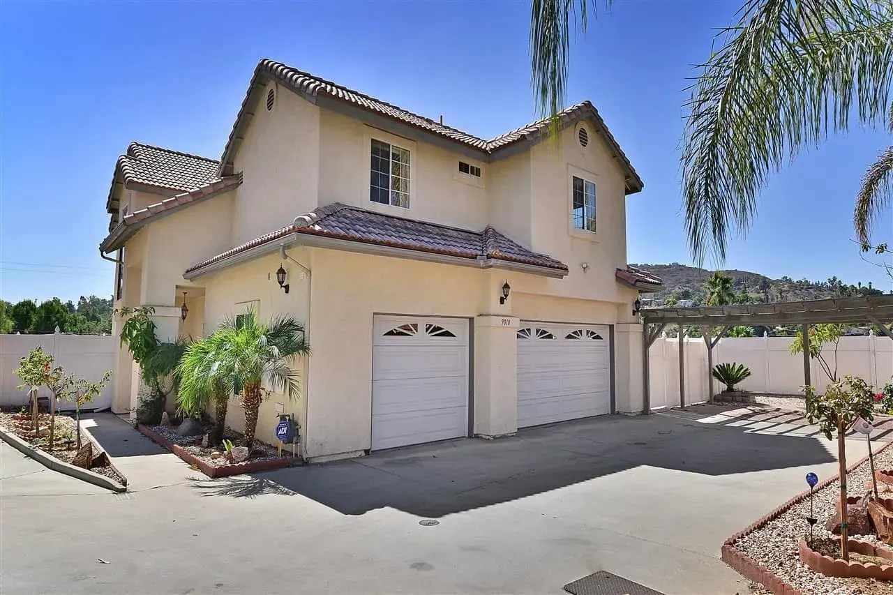 A large house with two garage doors and a pergola