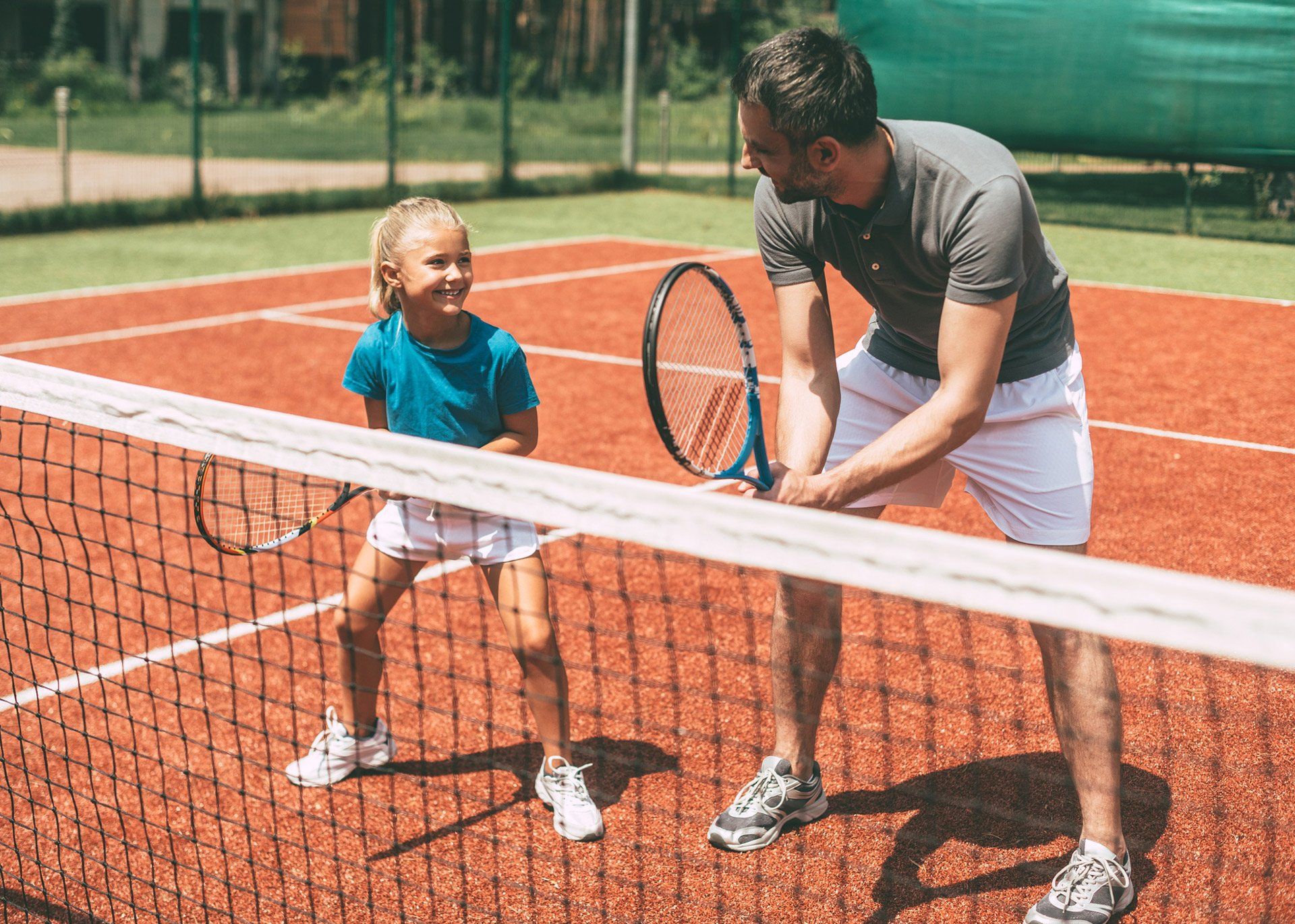 Father Teaching His Daughter to Play Tennis — Fort Collins, CO — New Colony Apartments
