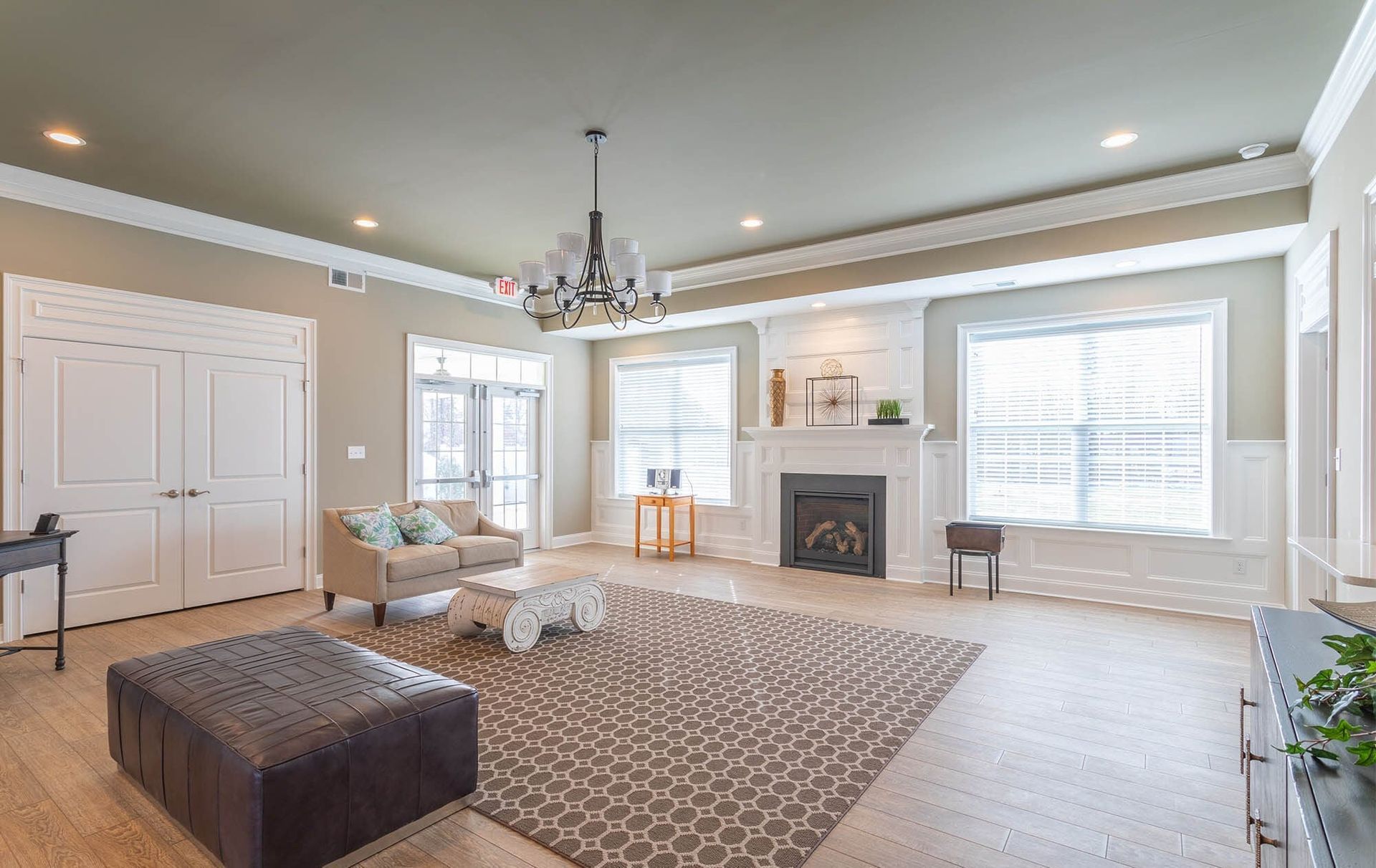 Bright living room with fireplace, large windows, and comfortable seating at The Residences at St. Joseph's Court in Levittown, PA.