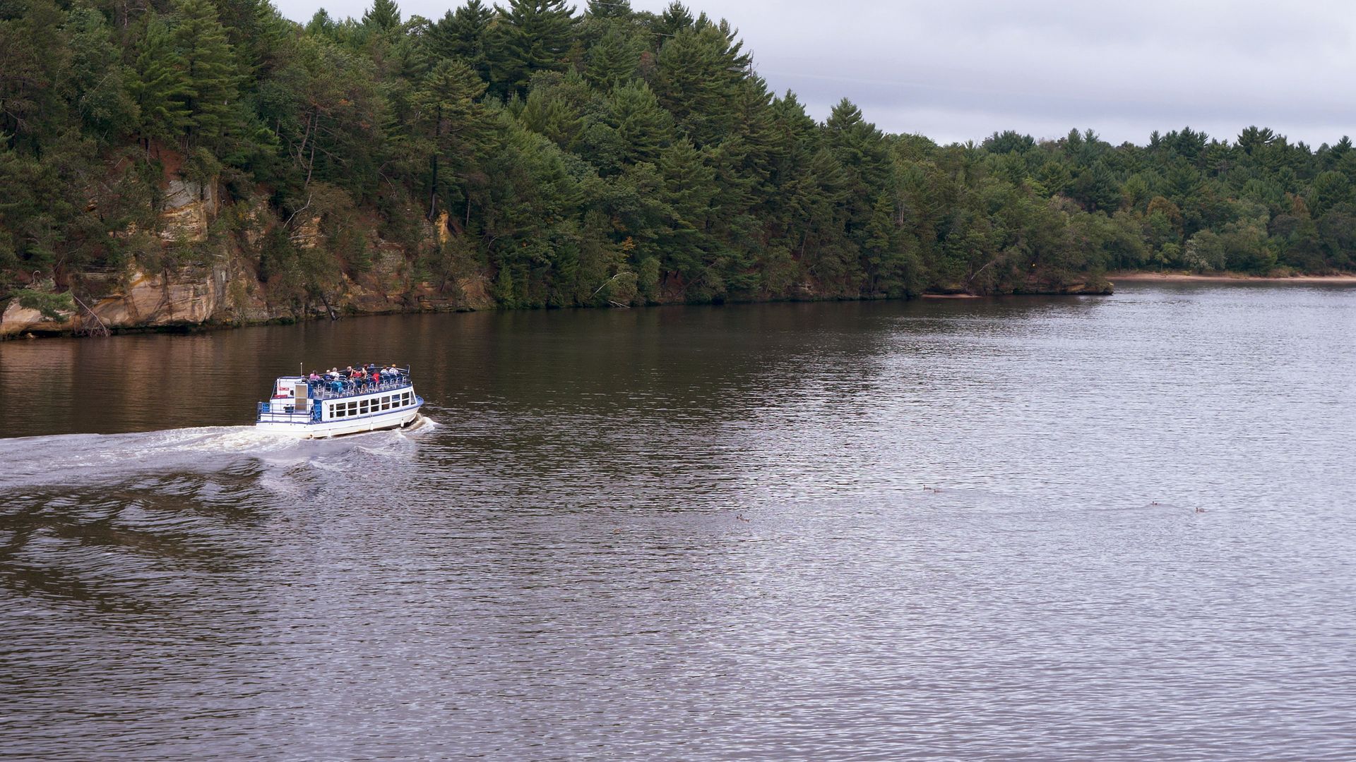 A boat is floating on a lake with trees in the background