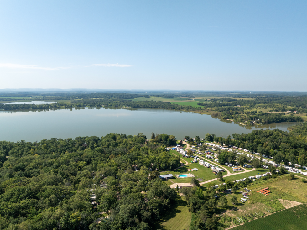 A campground with a lot of trees and a scenic lakeside view.