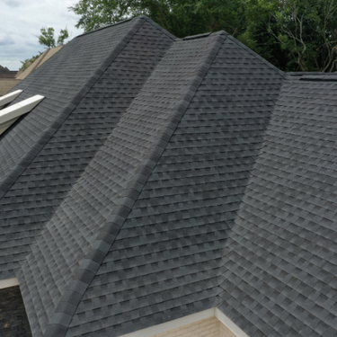 Dark gray shingle roof with multiple planes and a visible skylight.