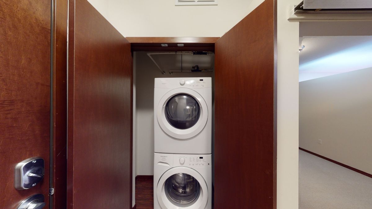 A washer and dryer are stacked on top of each other in a closet.