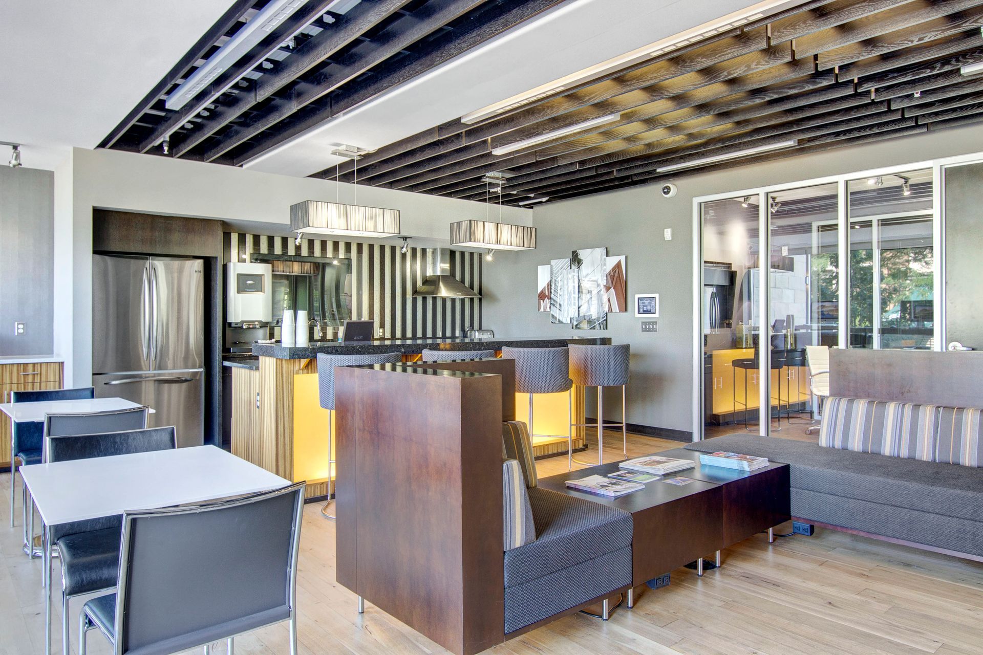 A large room with tables and chairs and a kitchen in the background.