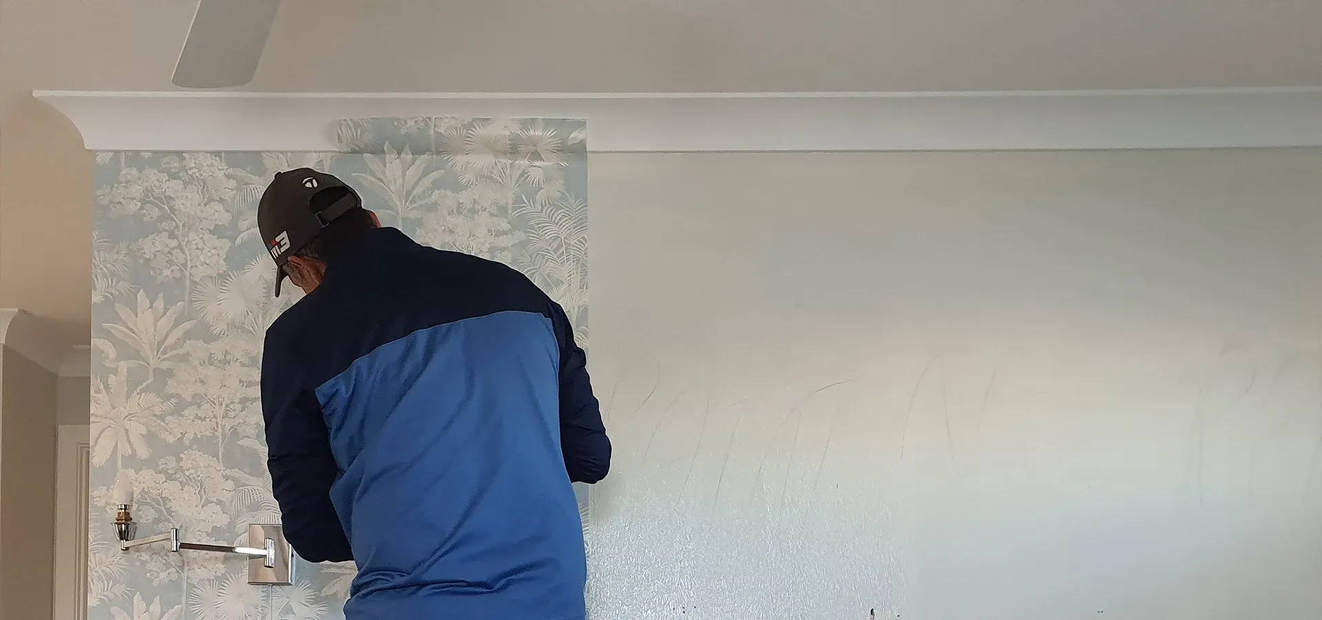 Man With Cap Installing Wallpaper | Cleveland, QLD | Miraje Home Decor & Soft Furnishings