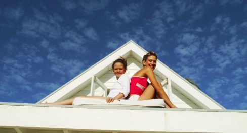 Two ladies sunbathing on a roof
