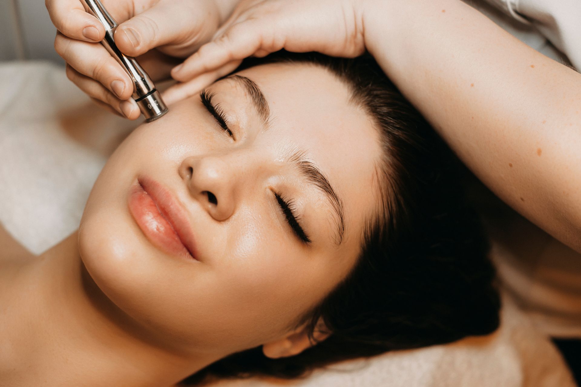 A woman is getting a facial treatment at a beauty salon.