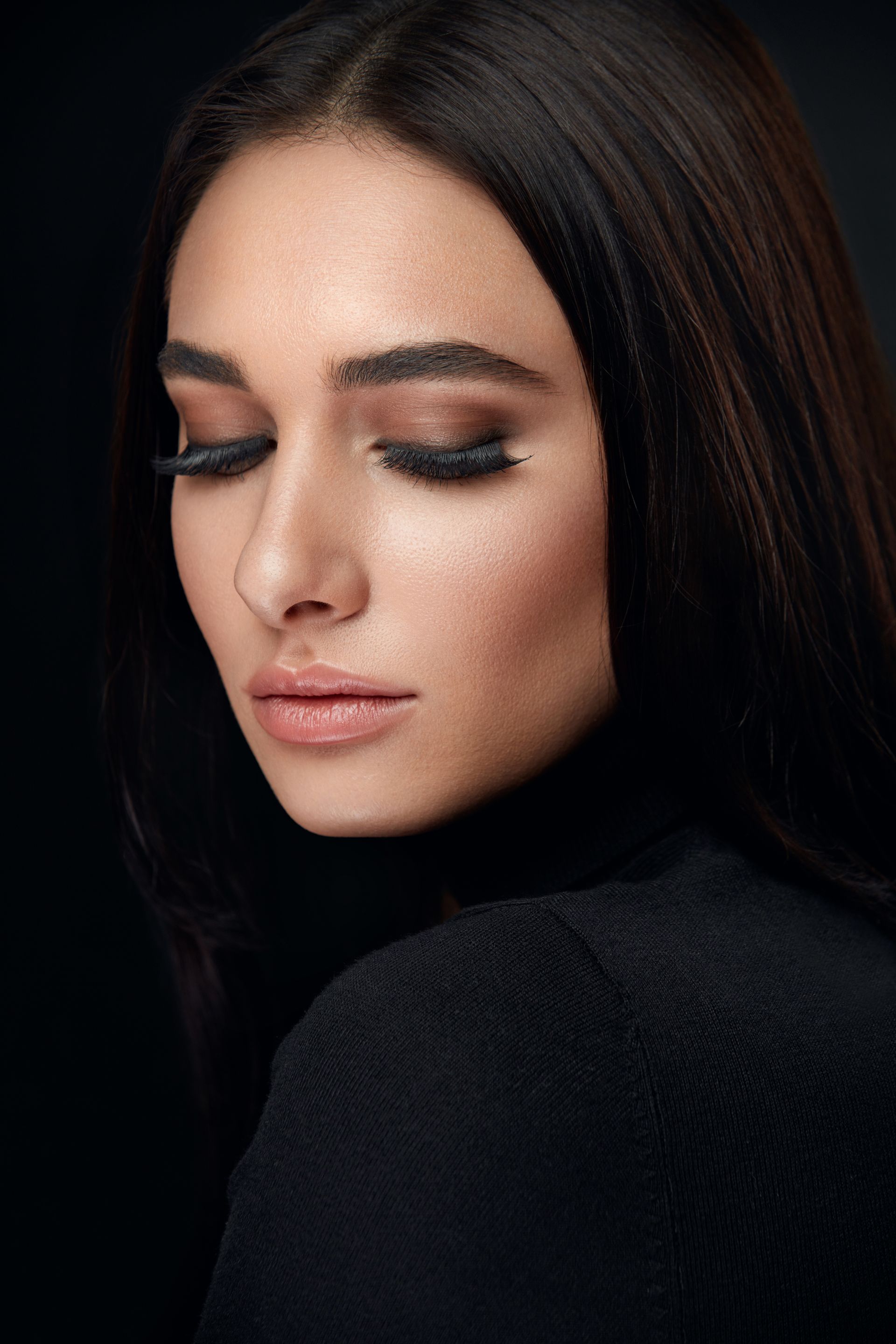 A close up of a woman 's face with her eyes closed.