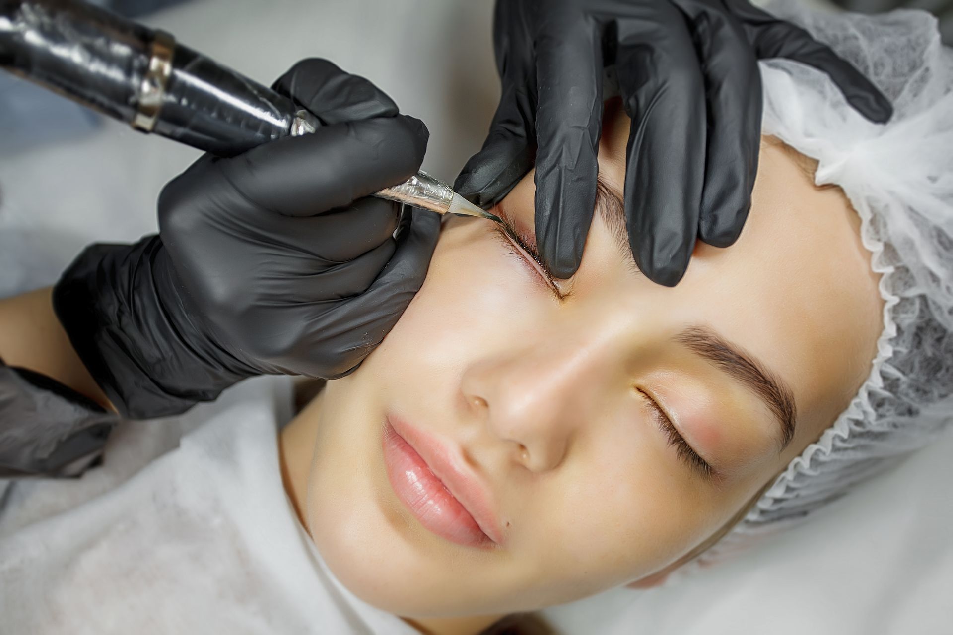 A woman is getting her eyebrows done at a beauty salon.