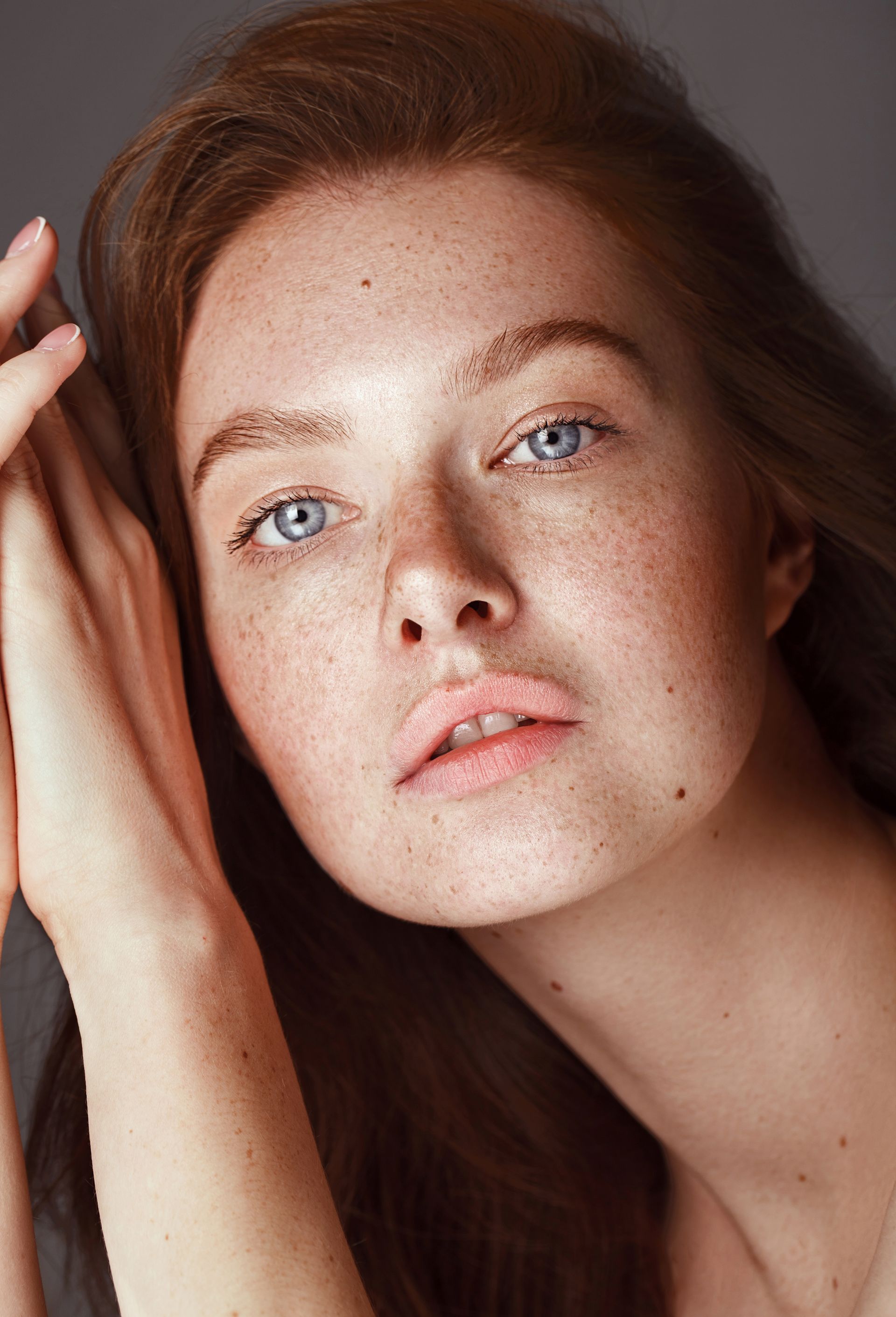 A close up of a woman 's face with freckles and blue eyes.