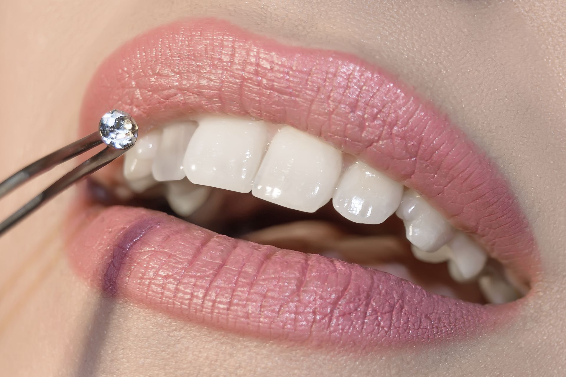 A close up of a woman 's mouth with a diamond in it.