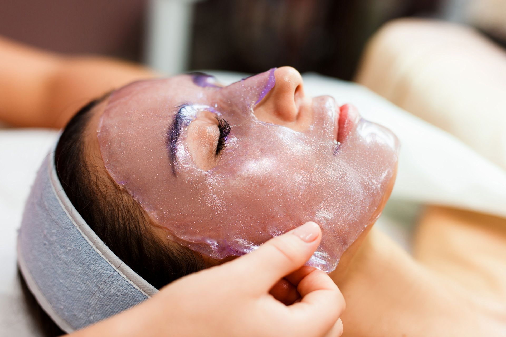 A woman is getting a facial treatment at a spa.