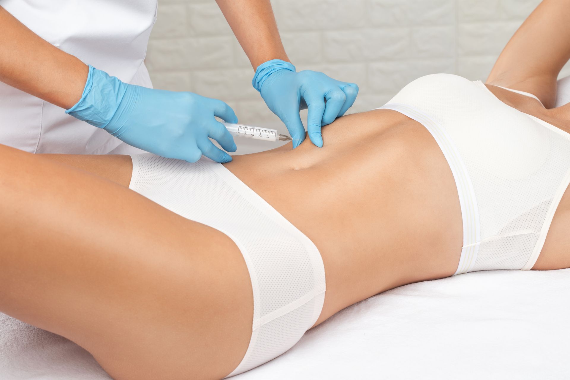 A woman is getting an injection in her stomach.