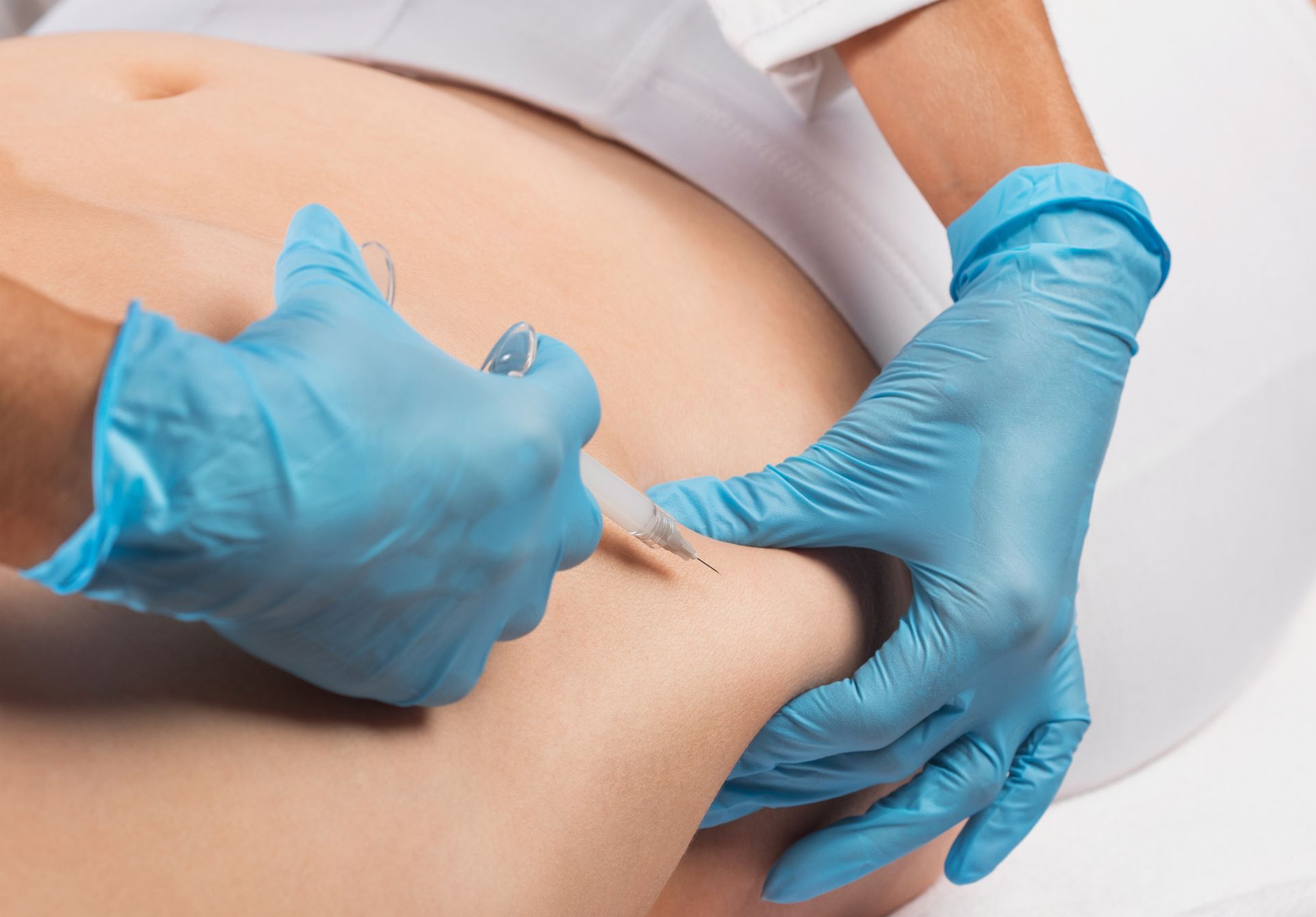 A woman is getting an injection in her stomach.