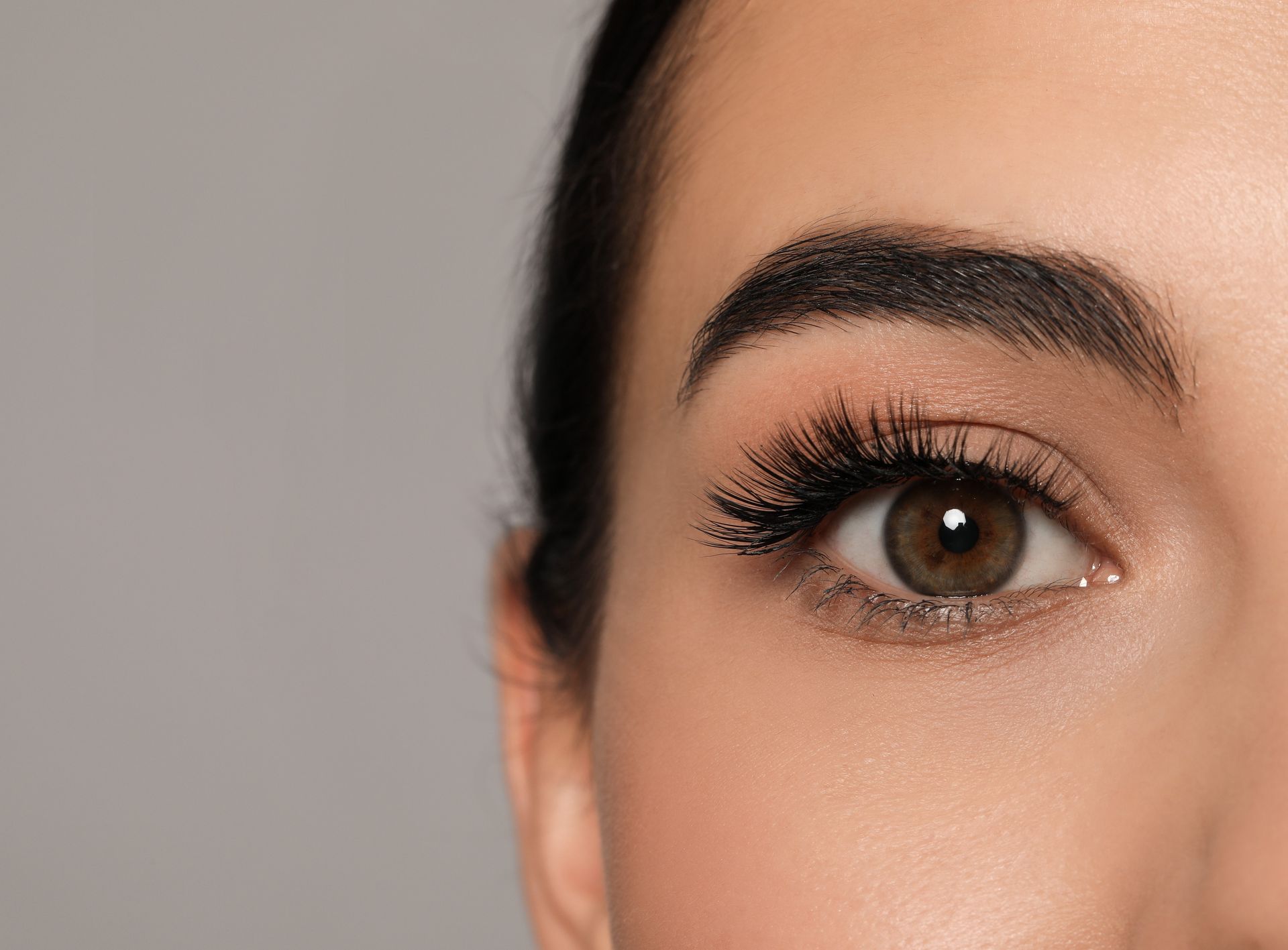 A close up of a woman 's eye with long eyelashes.