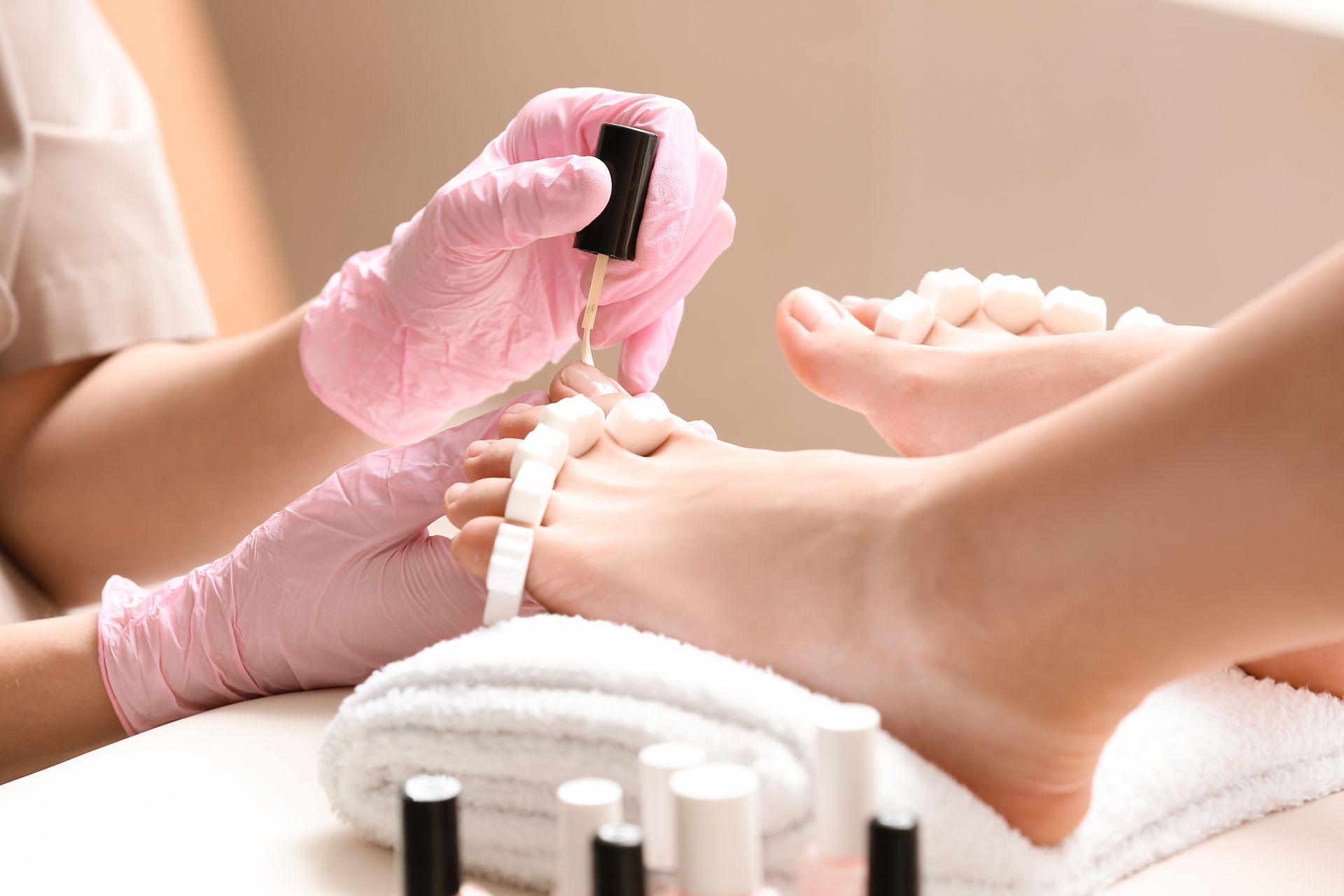 A woman is getting her feet painted at a nail salon.