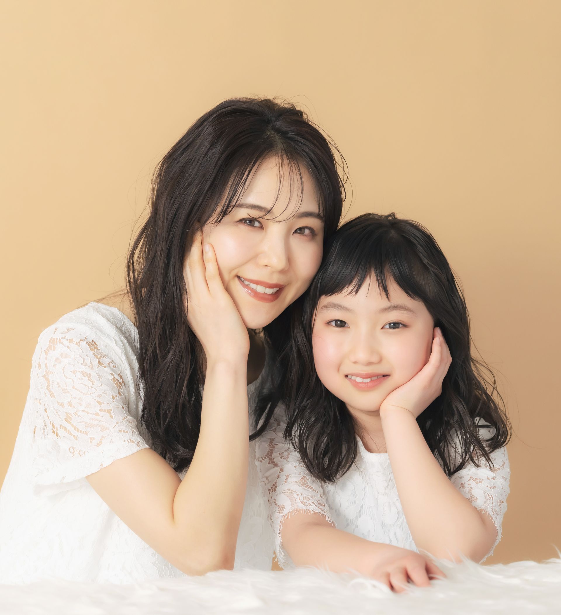 A woman and a little girl are posing for a picture together.