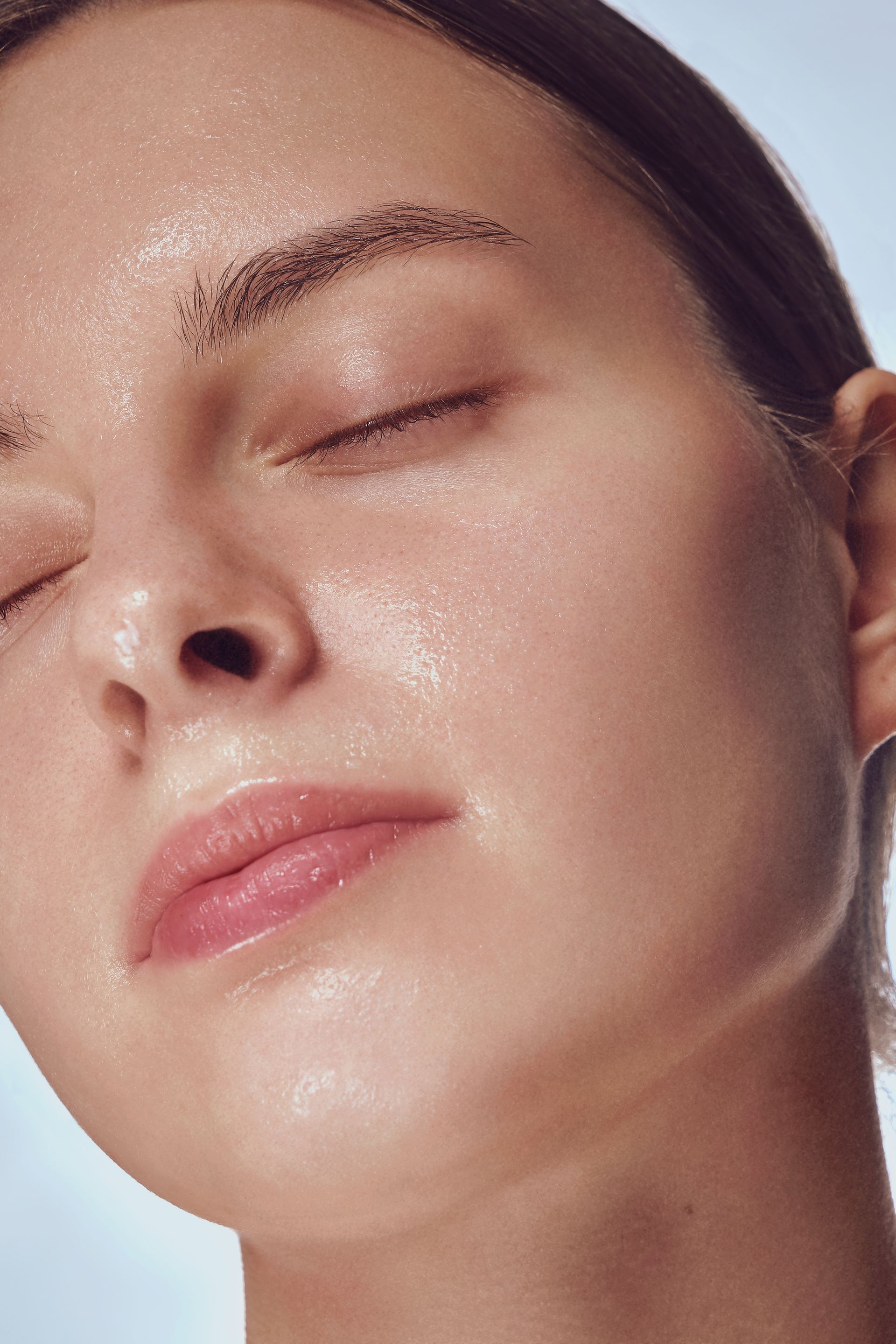 A close up of a woman 's face with sweat on it.