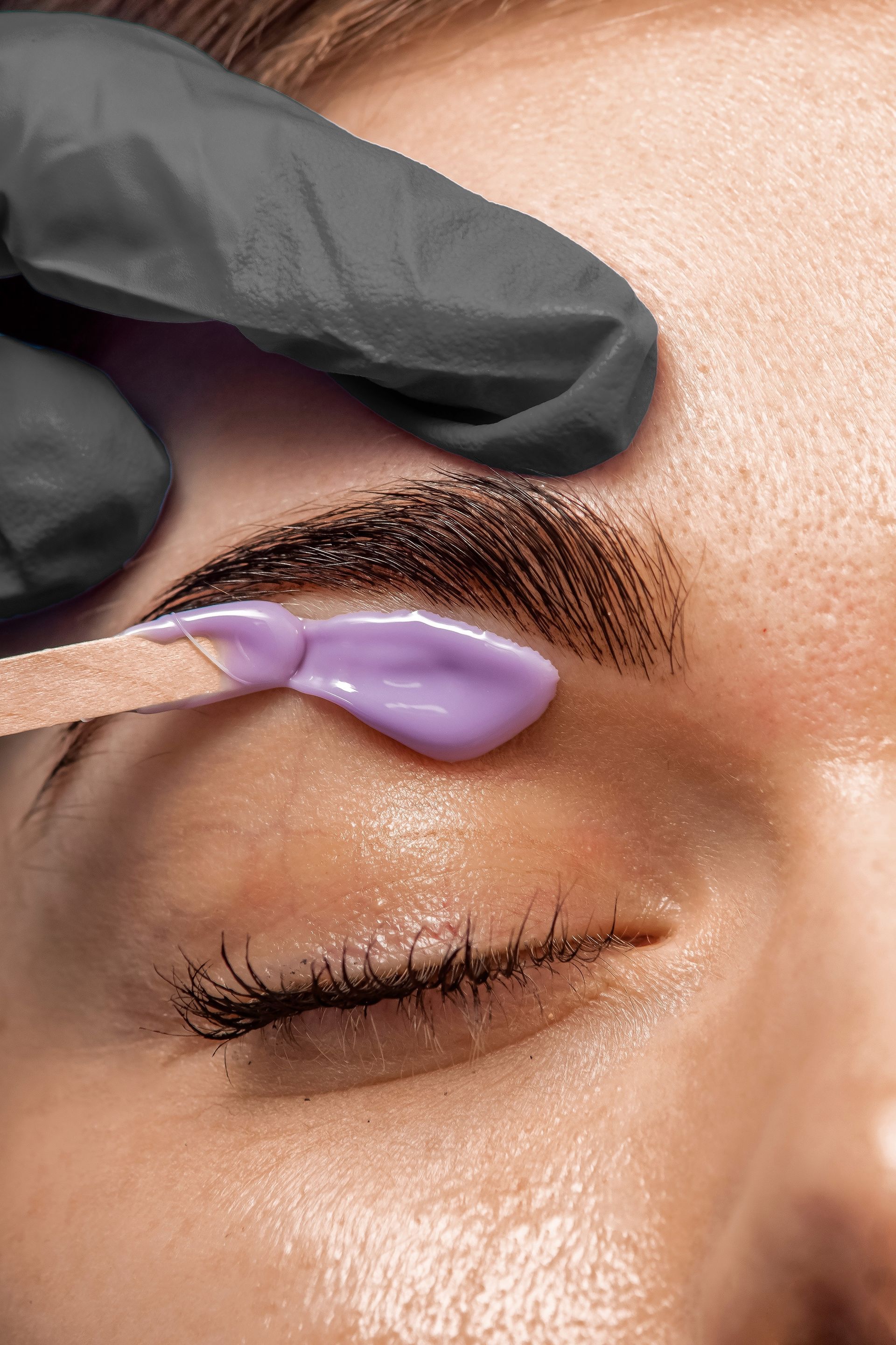 A woman is getting her eyebrows waxed in a beauty salon.