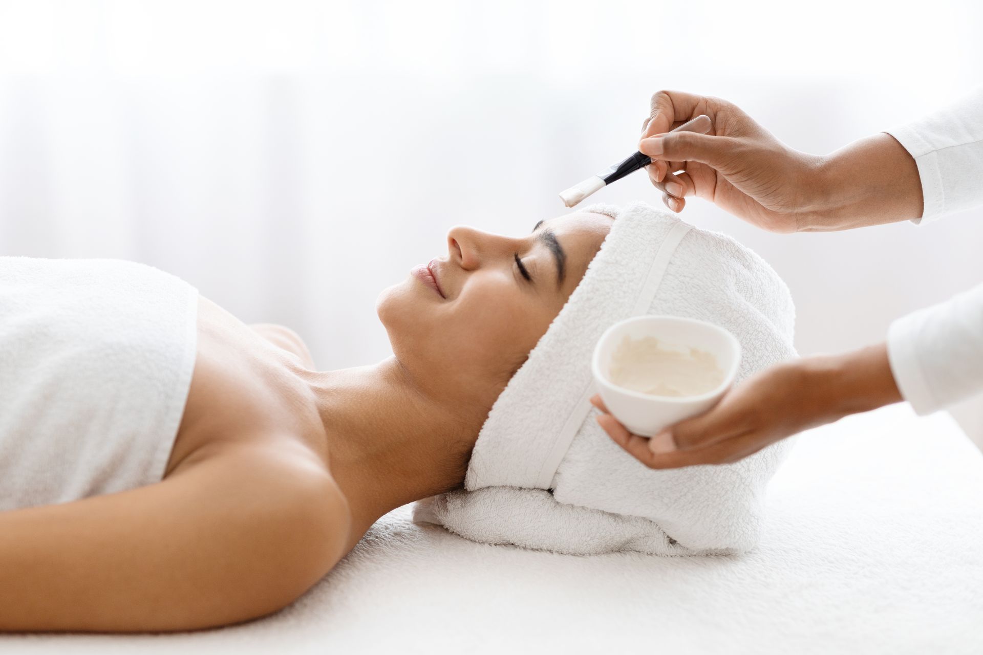 A woman is getting a facial treatment at a spa.