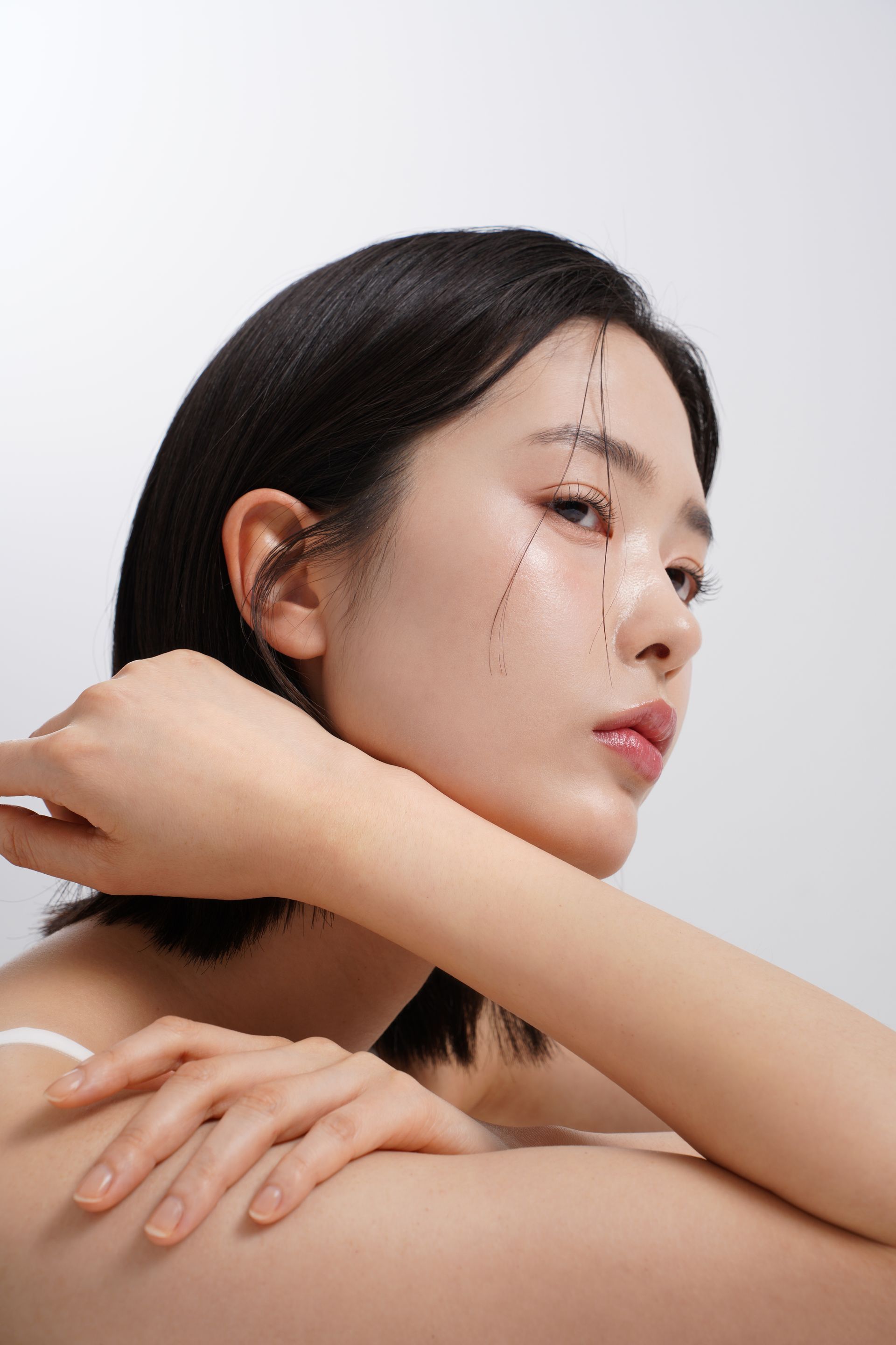 A close up of a woman 's face with her hand on her shoulder.