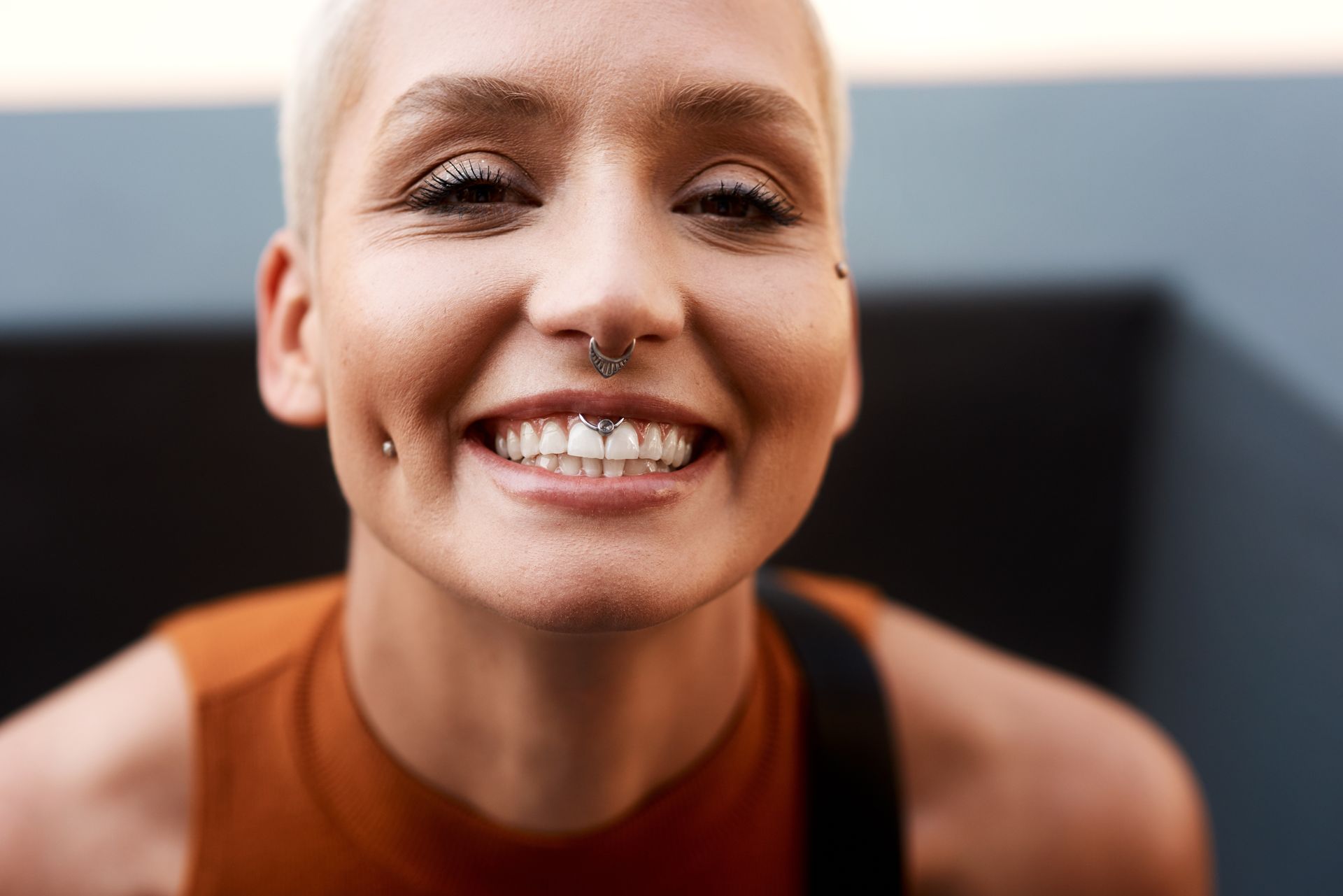 A close up of a woman with a nose ring smiling.