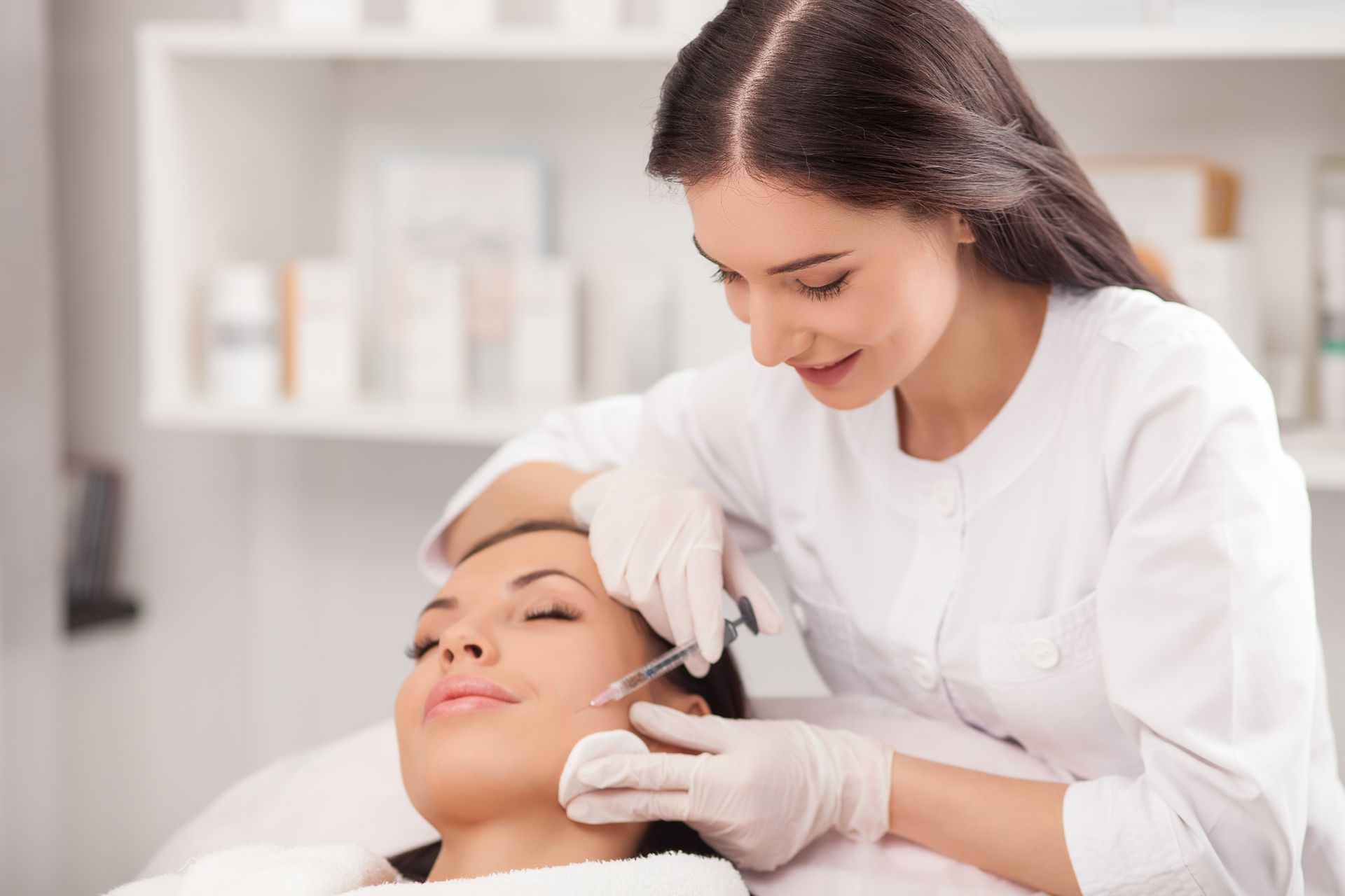 A woman is getting an injection in her face at a beauty salon.