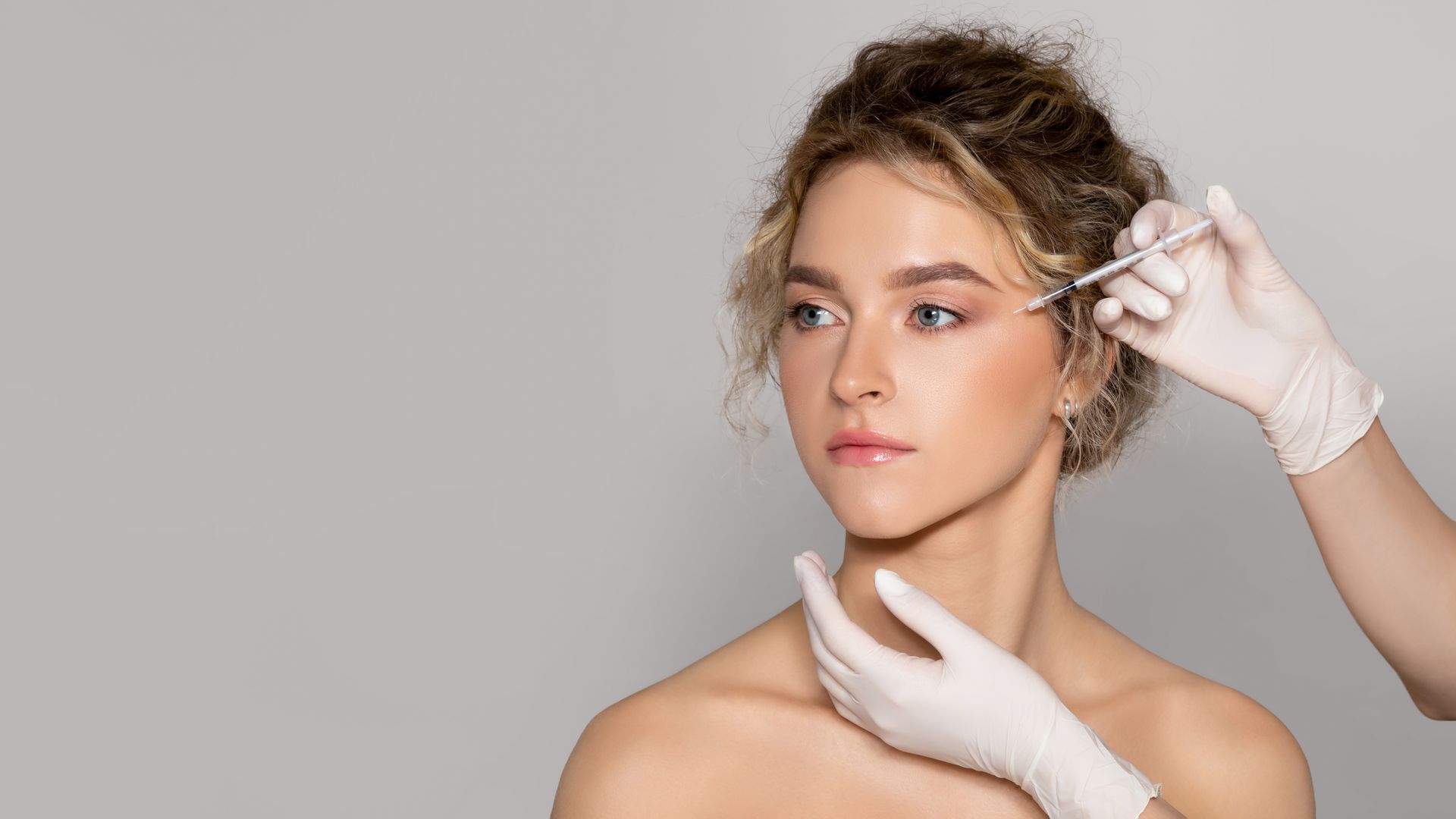 A woman is getting a botox injection in her face.