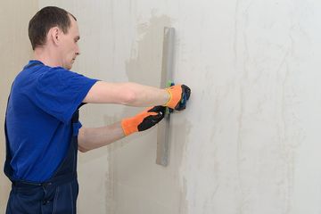 worker scraping the wall