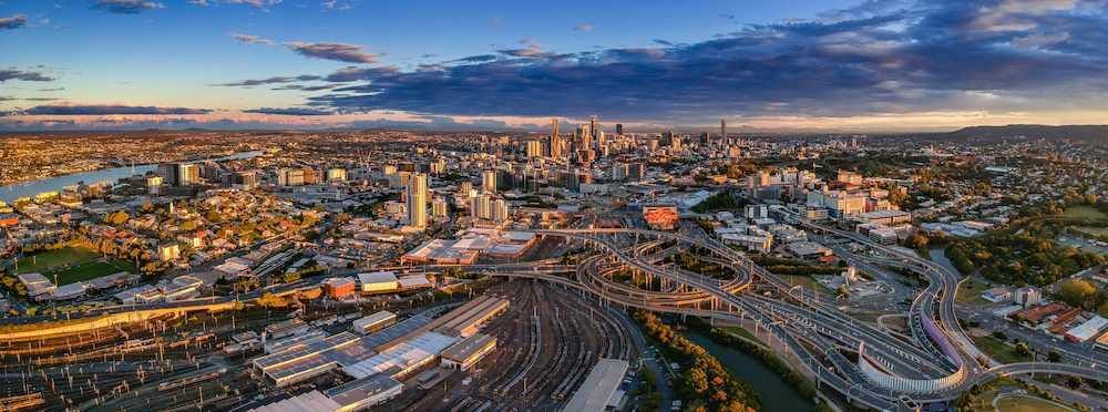 An Aerial View of a City at Sunset With a River Running Through It — Brisbane Antenna Specialists in Carindale, QLD