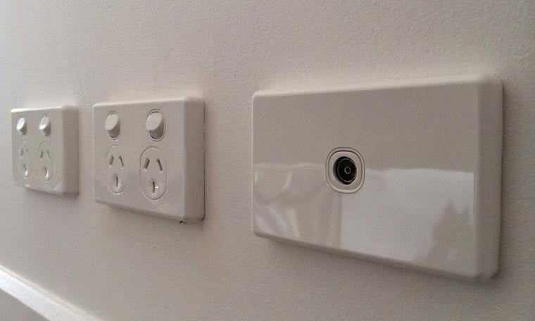 Three White Electrical Outlets Are Lined Up On A White Wall — Brisbane Antenna Specialists in Brendale, QLD