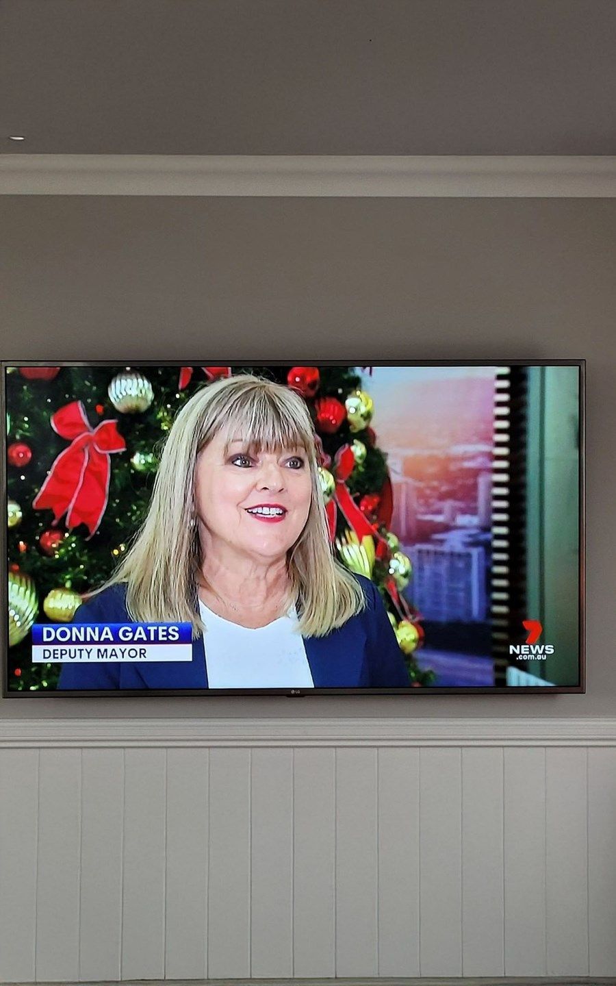 A Woman is Sitting in Front of a Christmas Tree on a Television Screen — Brisbane Antenna Specialists in Brendale, QLD