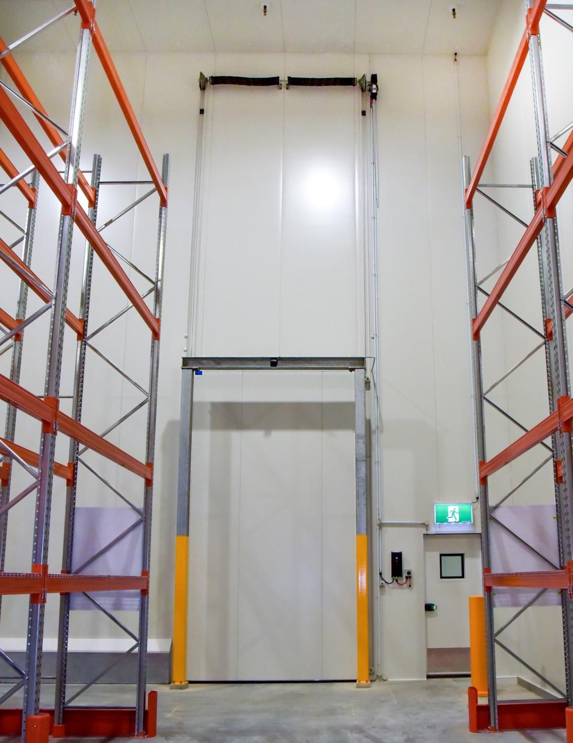 A Warehouse with A Green Exit Sign on The Wall — Arctic Installations in Winnellie, NT