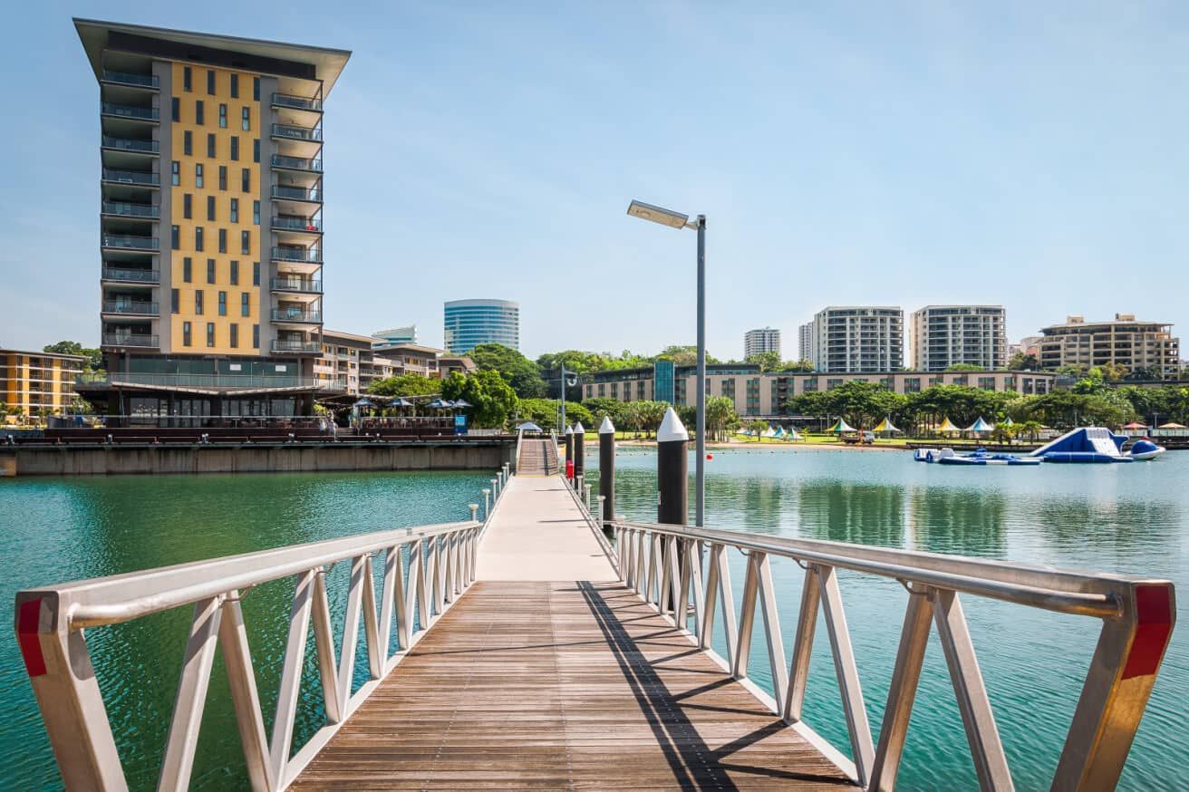A Dock Leading to A Body of Water with A Tall Building in The Background — Arctic Installations in Winnellie, NT