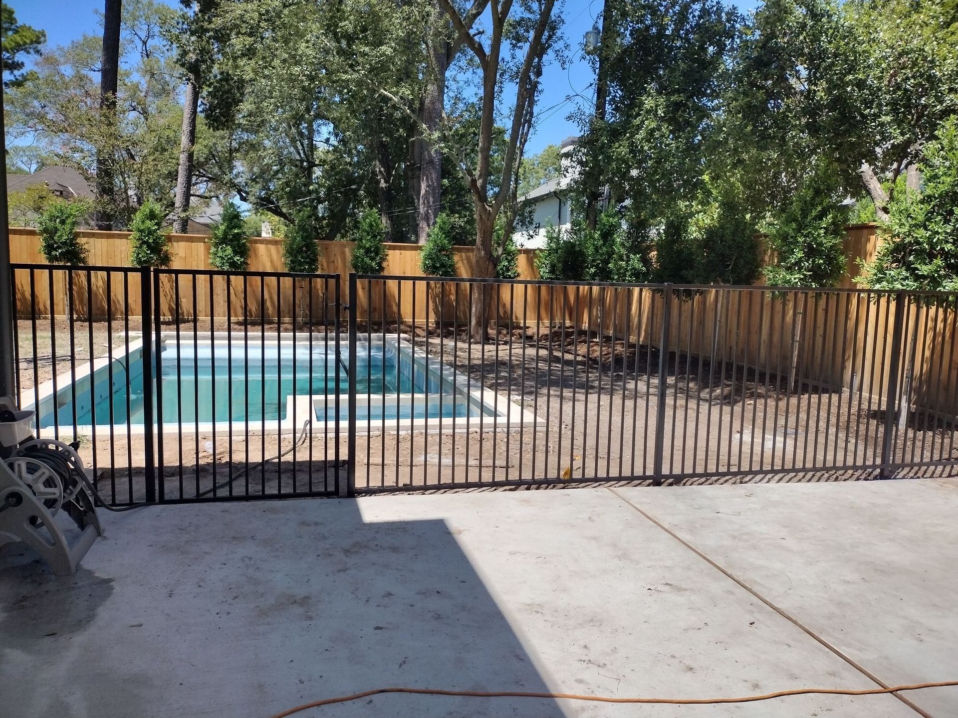 A Fence Surrounds a Swimming Pool in A Backyard - Houston, TX - Rio Grande Fence Company