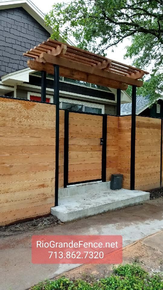 A Wooden Fence With A Pergola and A Gate in Front of A House - Houston, TX - Rio Grande Fence Company