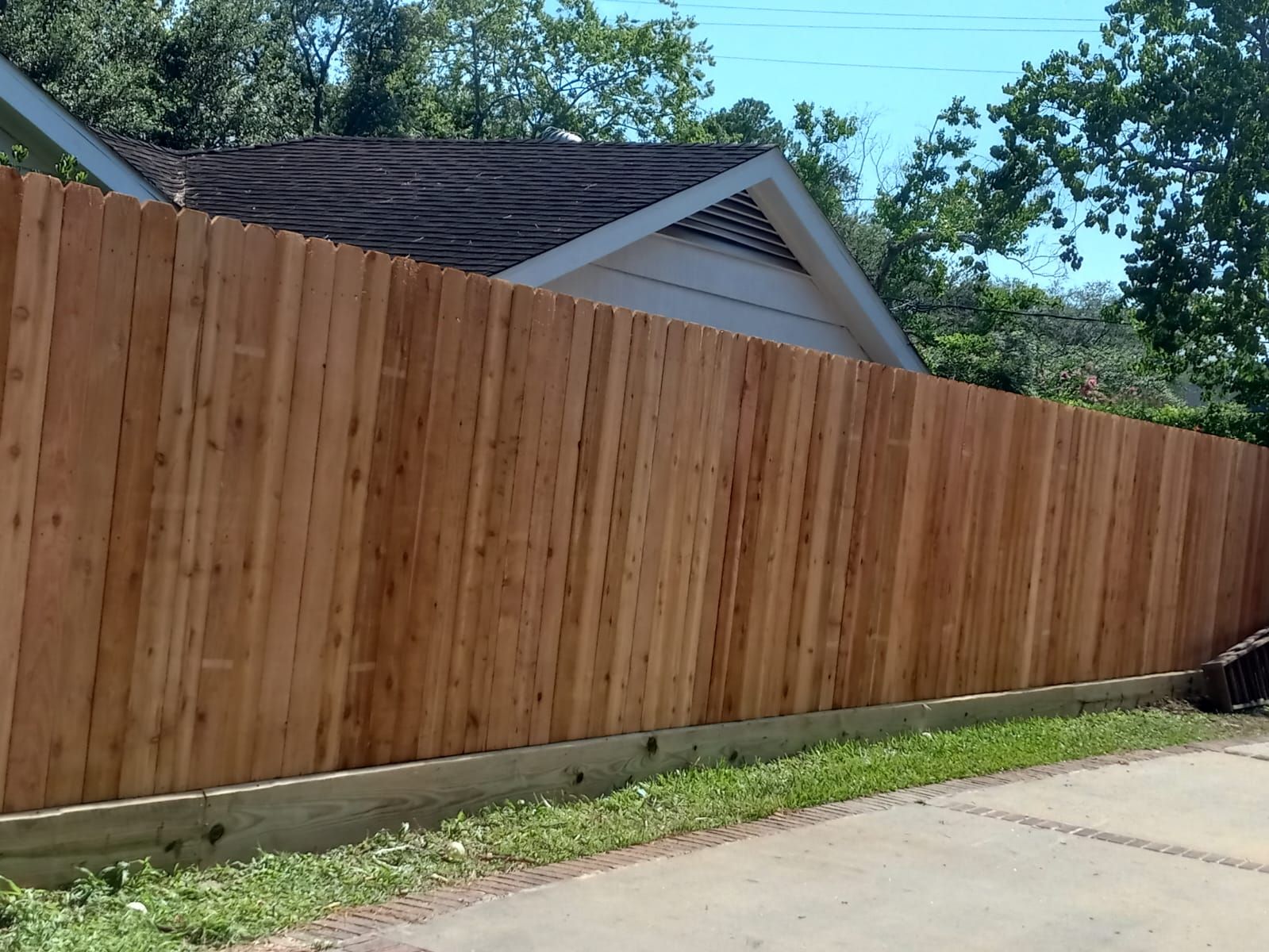 A Wooden Fence with A House in The Background - Houston, TX - Rio Grande Fence Company