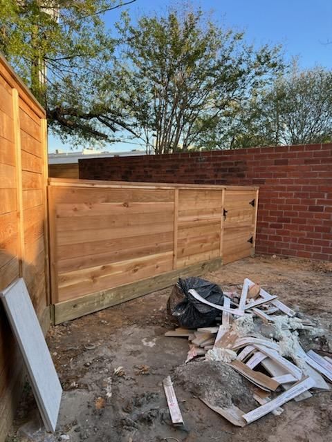 A Wooden Fence Is Being Built in A Backyard Next to A Brick Wall - Houston, TX - Rio Grande Fence Company