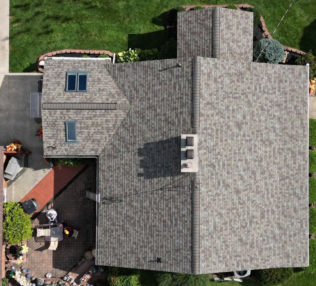 an aerial drone photo of a house who's roof and skylight windows were installed by top shelf