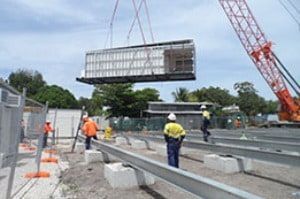 A crane is lifting a large piece of metal into the air.