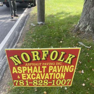 Norfolk Asphalt Paving & Execution sign in a yard in Canton, MA