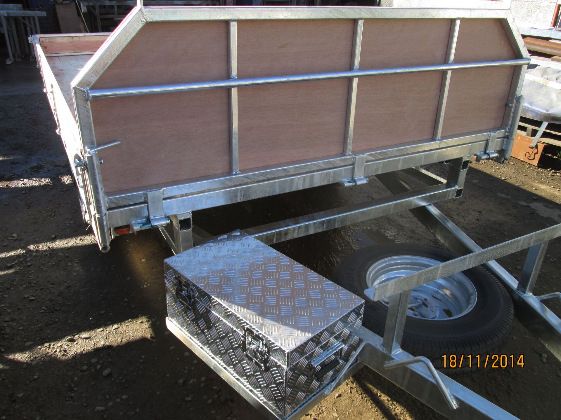Silver minivan towing a trailer on a highway, with a cargo box on the roof.