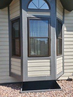 A house with a porch and a window on the side of it.