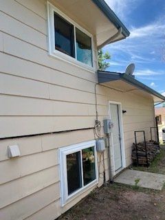 The side of a house with a window and a door.