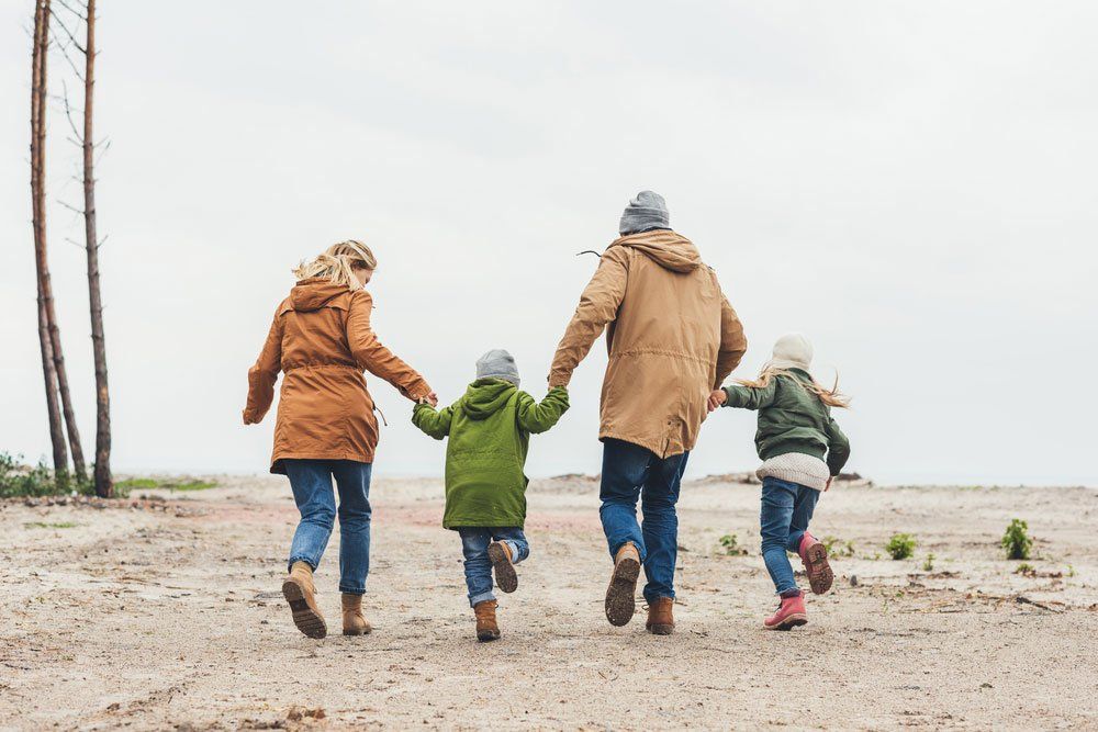 Family Running Together On Beach — Quality Shoe Shop in Maroochydore, QLD