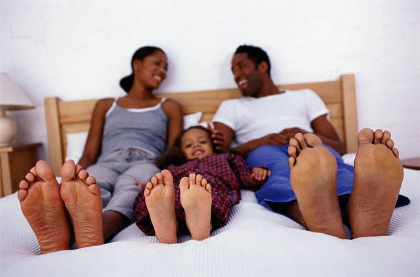Happy Family Sitting on a Bed  — Quality Shoe Shop in Maroochydore, QLD
