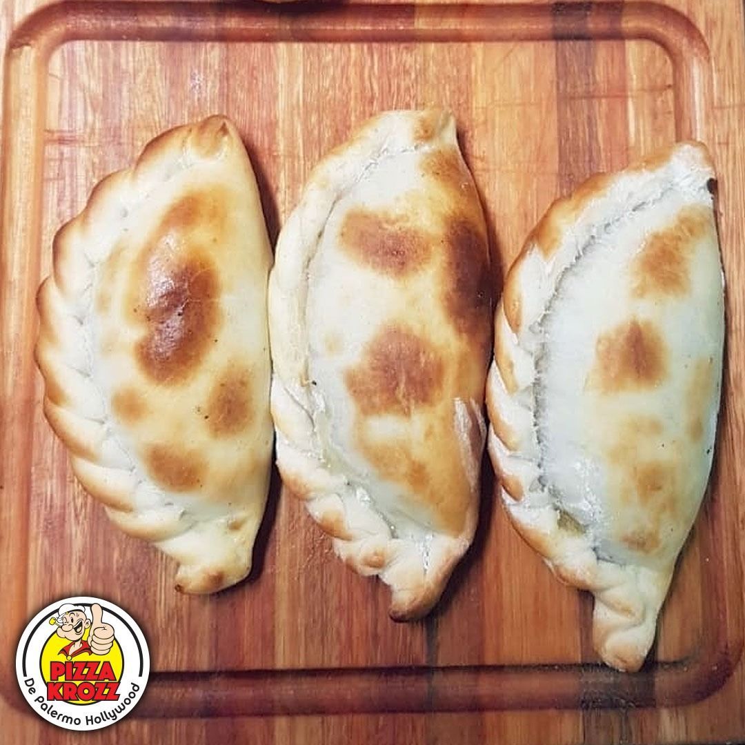 Tres empanadas horneadas de color dorado con bordes ondulados